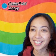 Smiling woman with long, dark hair on a multicolored background
